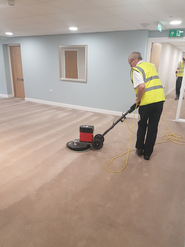 Cleaning a carpet in a commercial space.